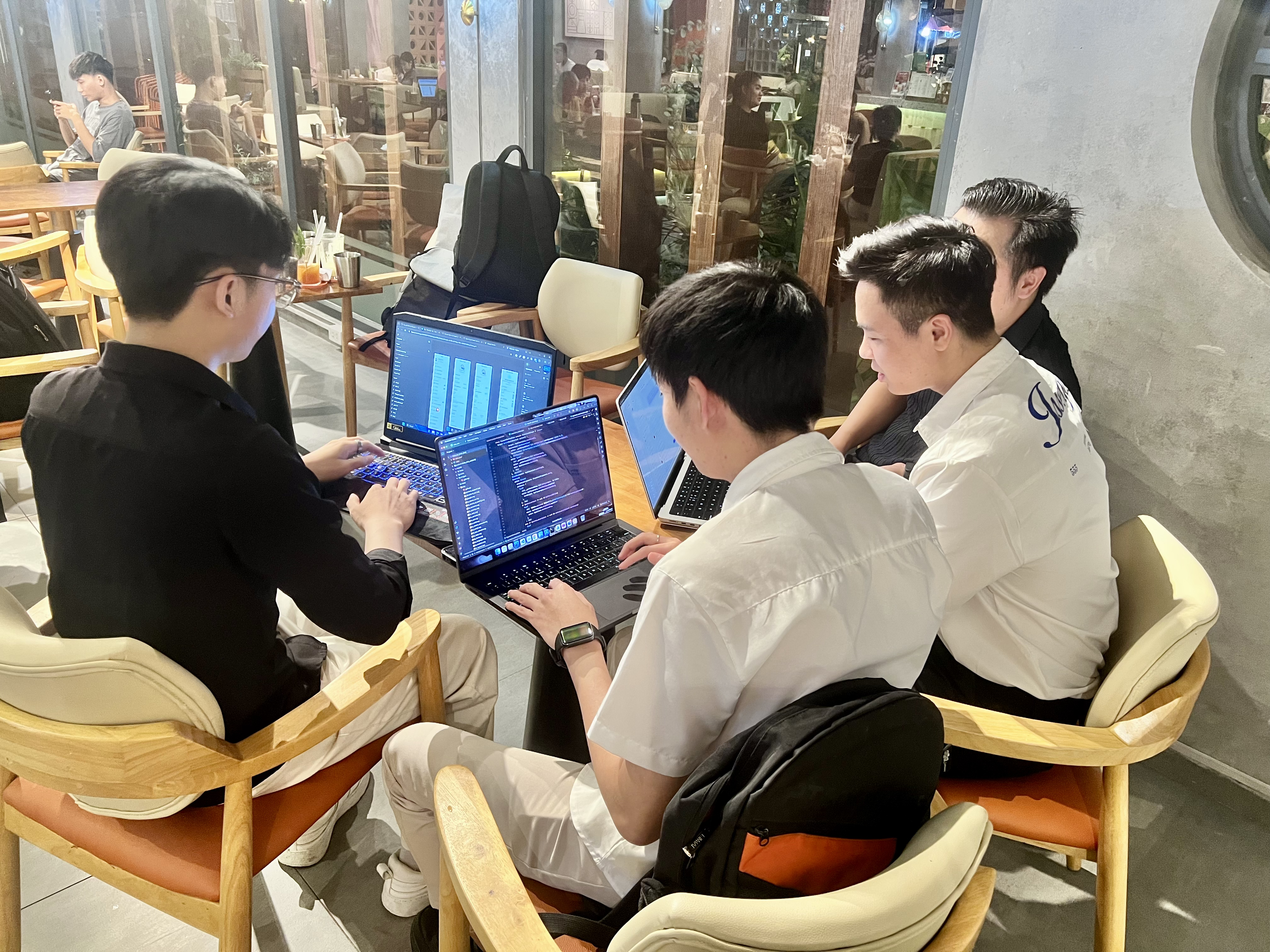 startup founders brainstorming ideas in coffee shop with laptops and notebooks, entrepreneurial spirit